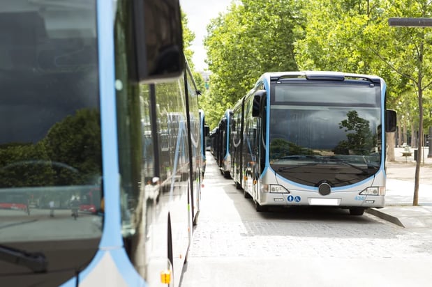 Several public transit buses lined up for routine fueling and fluids management..