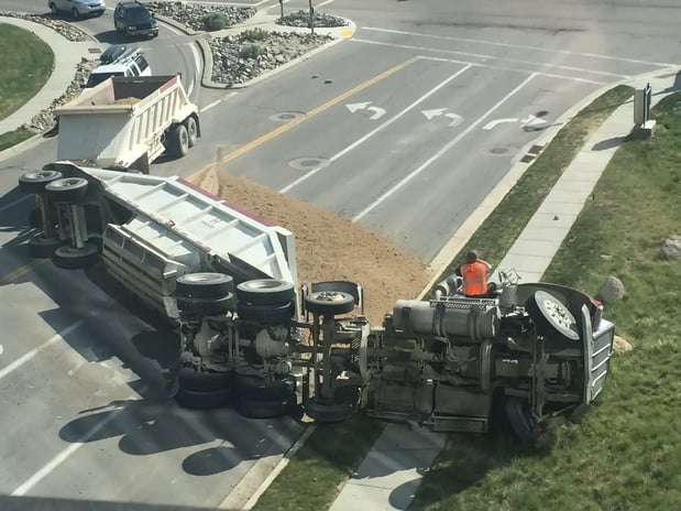 commercial haul truck on its side in the middle of an intersection.