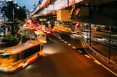 bus rushing by on city street in evening sm2-fuel transit