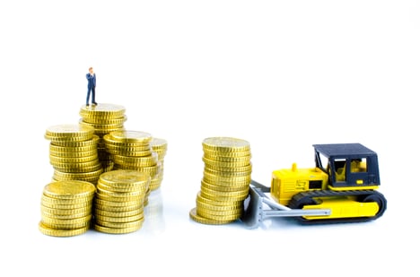 Businessman On A Pile Of Coins-AdobeStock_58347743