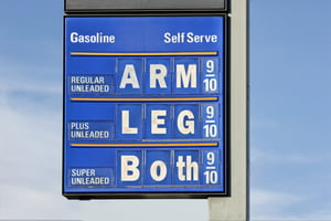 Gas Price Humor with a sign indicating gas  will cost a arm, leg or both.